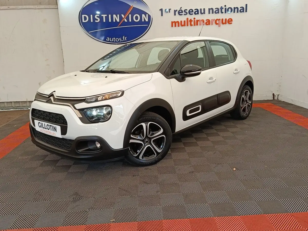Citroën C3 blanc vue 3/4 avant droit, avec protections latérales noires et jantes alliage distinctives.