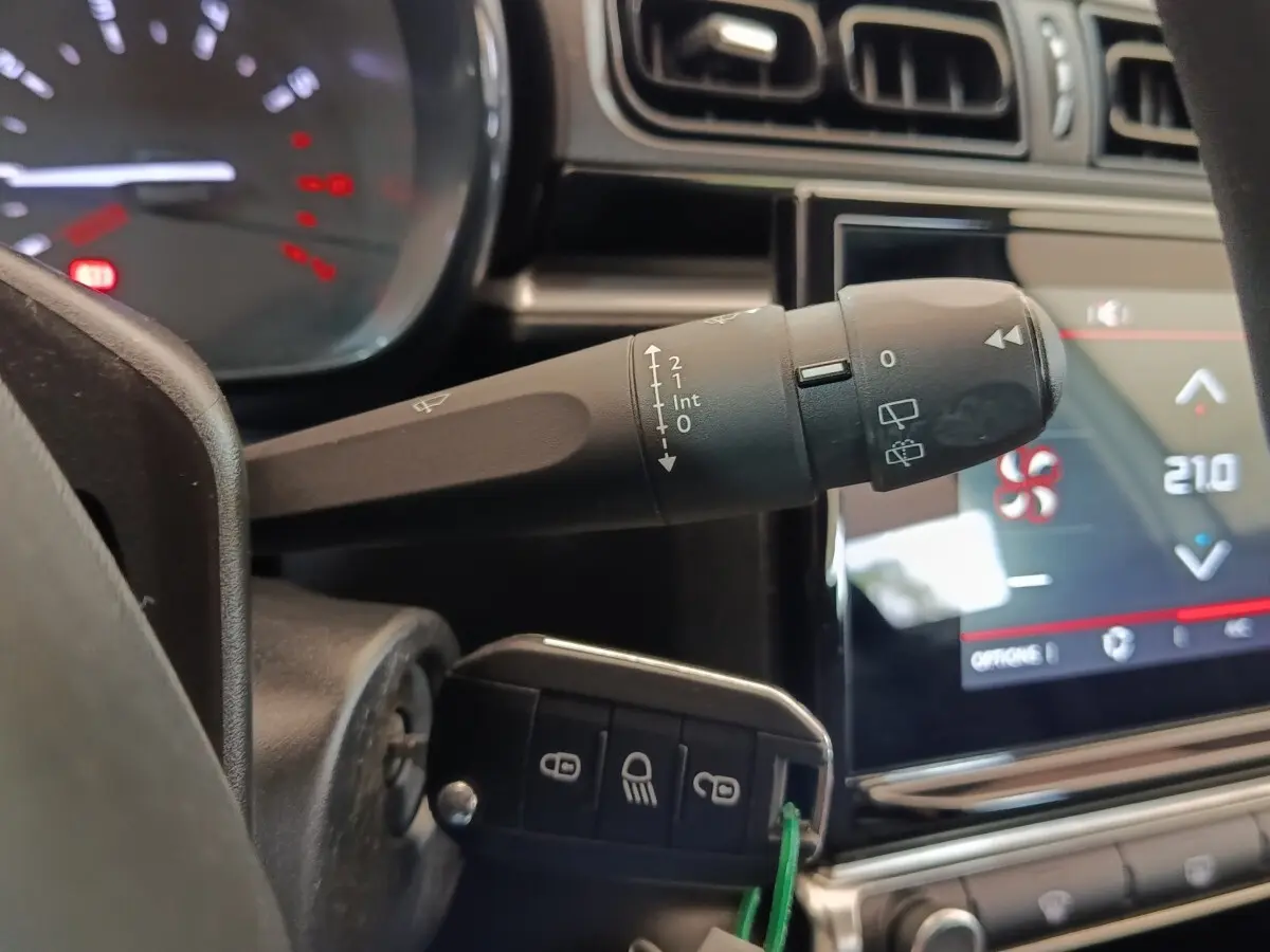 Gros plan sur la commande d'essuie-glace et le tableau de bord tactile de la Citroën C3 blanche, version 2022.