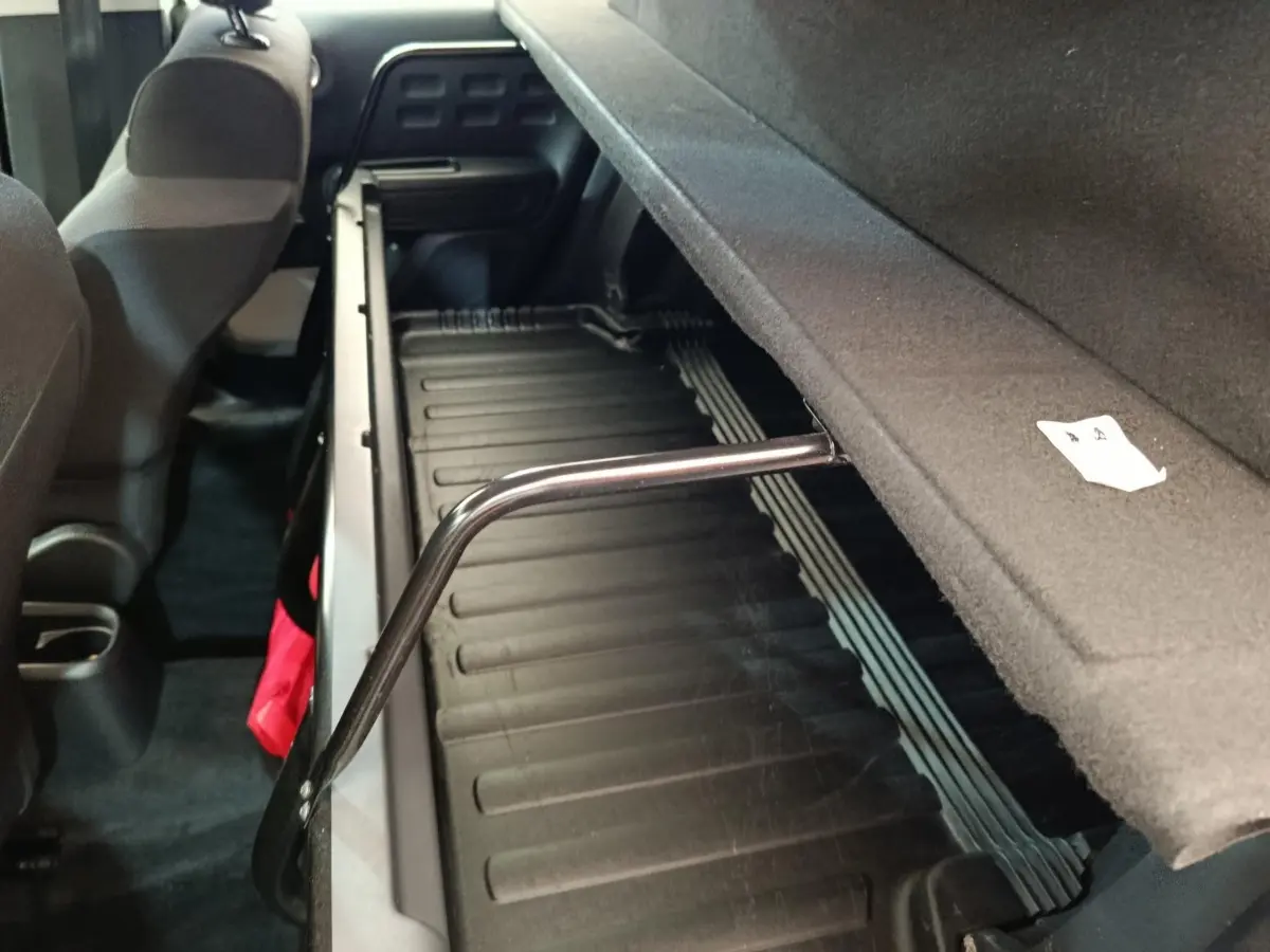 Vue intérieure arrière de la Citroën C3 blanche, montrant le coffre avec tablette de séparation relevée.