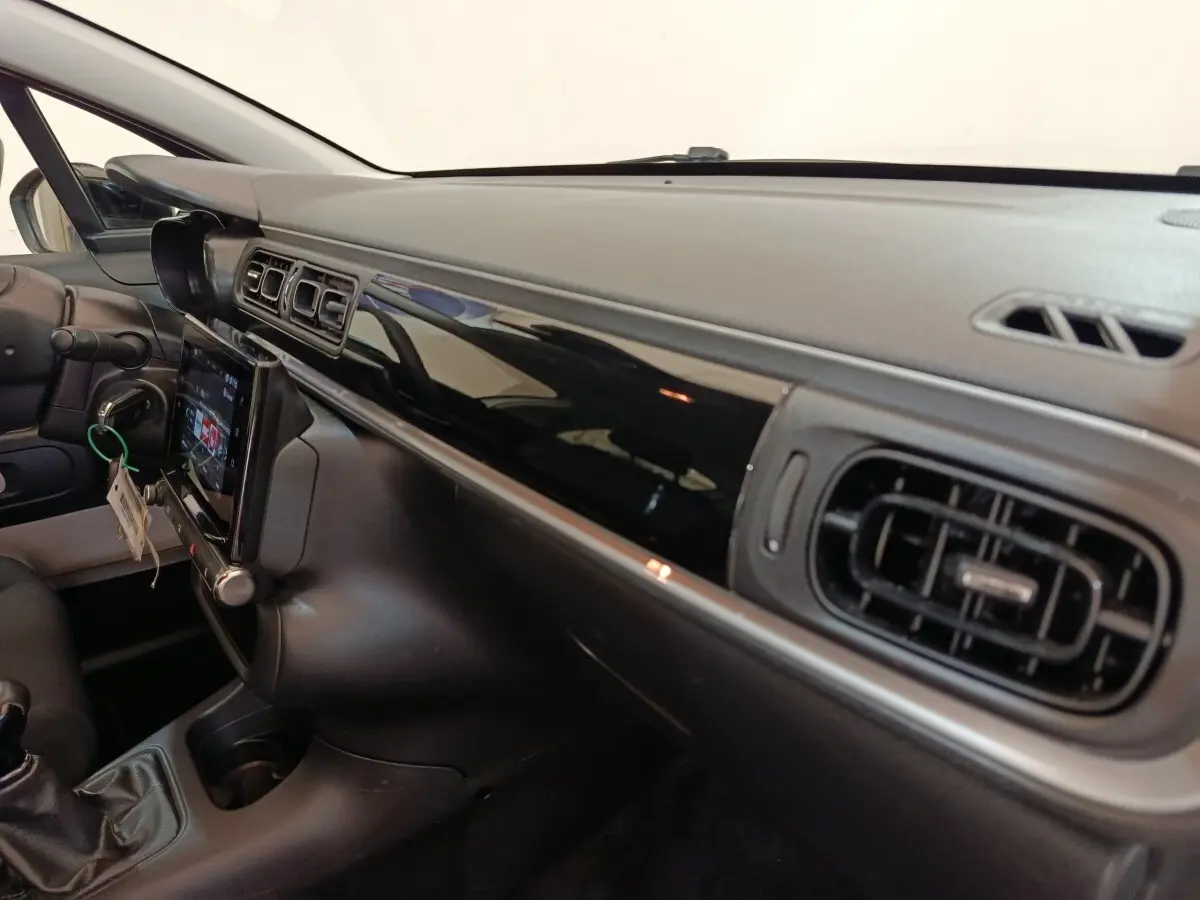 Vue intérieure côté passager du tableau de bord noir brillant et écran tactile de la Citroën C3 PureTech 2022.