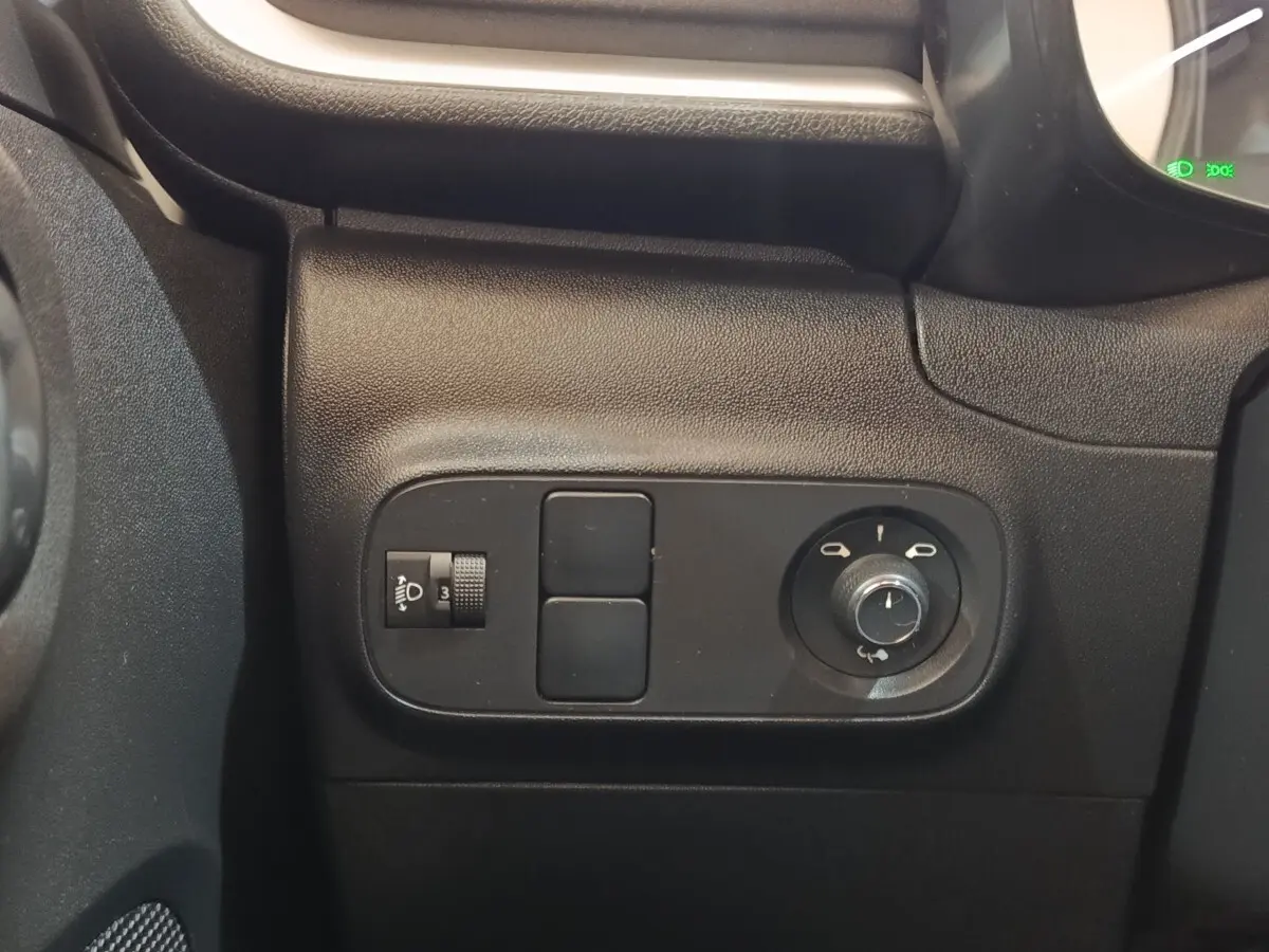 Détail des commandes de réglage des phares et des rétroviseurs côté conducteur dans une Citroën C3 blanche 2022.
