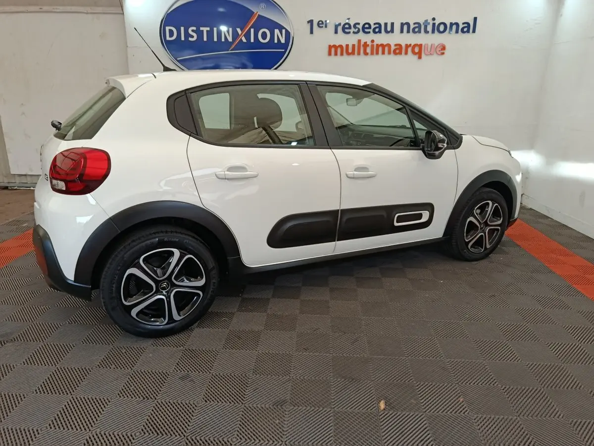 Vue latérale droite d'une Citroën C3 blanche 2022 avec protections latérales noires et jantes alliage distinctives.