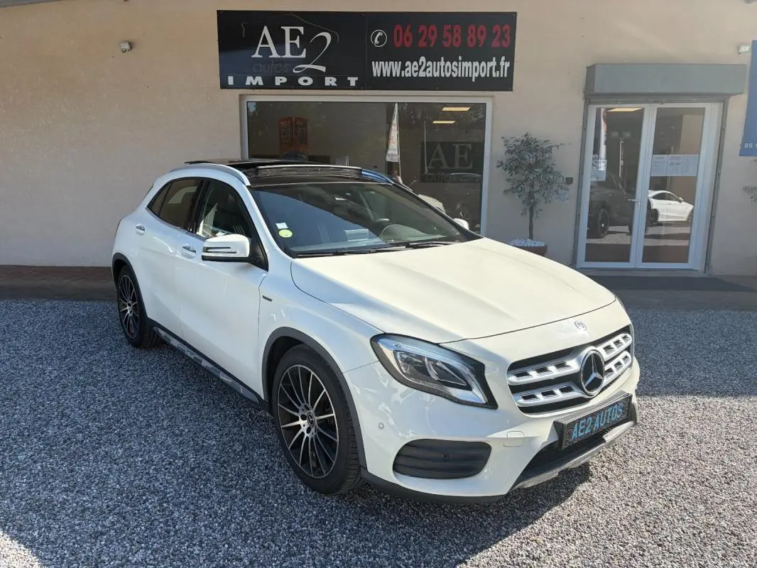 Mercedes GLA 220d blanc en 3/4 avant droit, avec jantes noires et toit ouvrant panoramique visible.