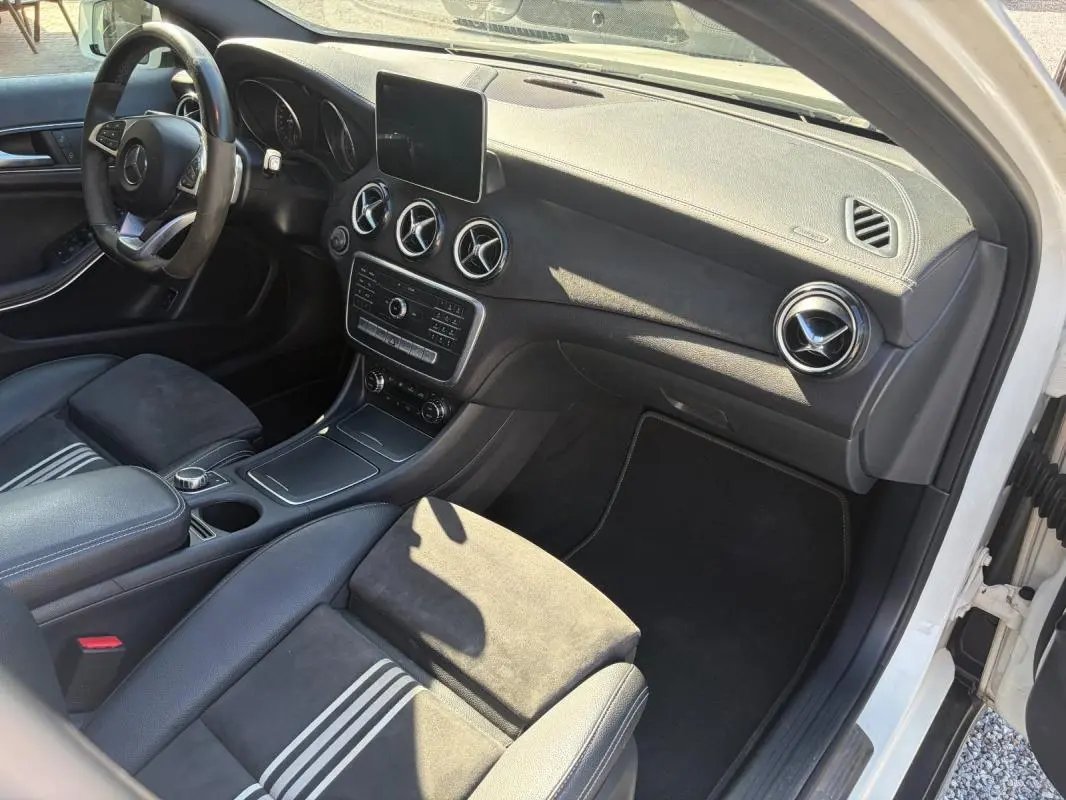 Vue intérieure côté passager du Mercedes GLA 220d blanc 2017, avec tableau de bord noir et aérateurs ronds chromés.