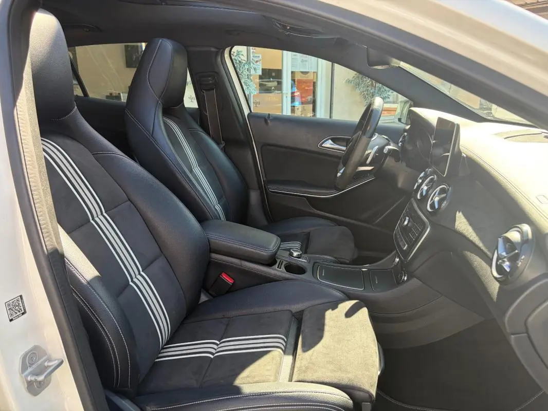 Intérieur de la Mercedes GLA 220d 2017 vue côté gauche, sièges noirs avec bandes blanches distinctives.