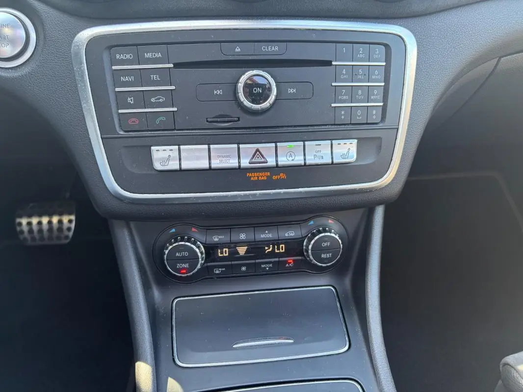 Vue rapprochée du tableau de bord central et de la console de la Mercedes GLA 220d White Art Edition 2017, avec commandes audio et climatisation.