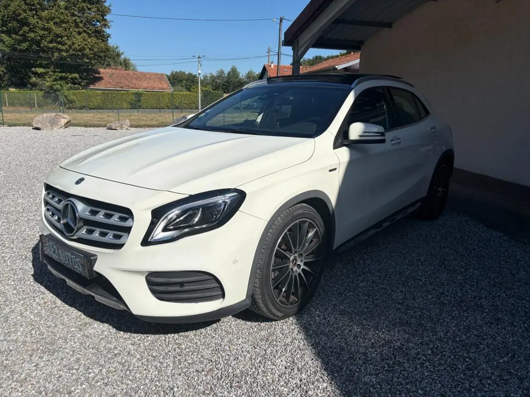 Mercedes GLA 220d blanc vue 3/4 avant droit, jantes noires et toit panoramique sous un abri extérieur.