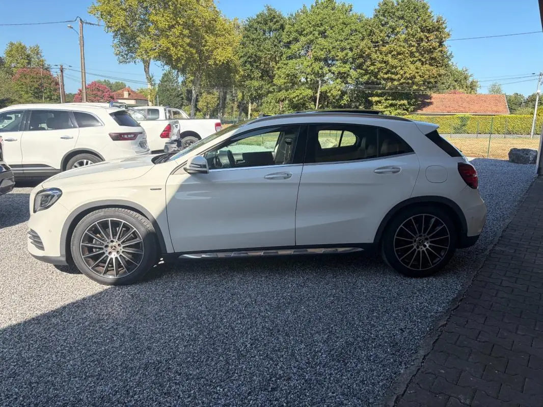 Mercedes GLA 220d blanc vue de profil côté gauche, avec jantes alliage distinctives et toit noir contrastant.