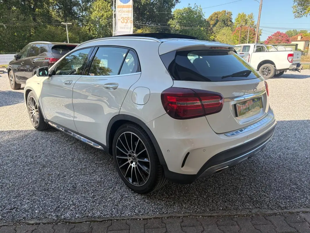 Mercedes GLA 220d blanc en vue 3/4 arrière droit, avec jantes noires et toit panoramique noir.