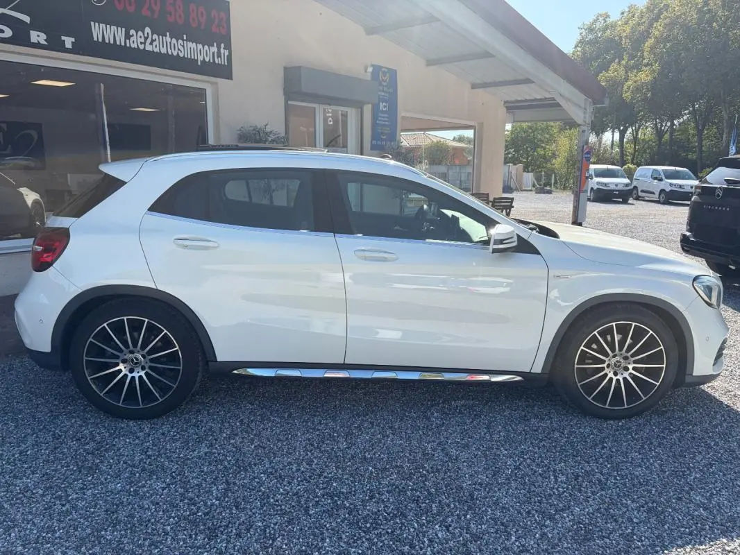 Vue de profil côté gauche d'un Mercedes GLA 220d blanc avec jantes alliage et bas de caisse chromé, stationné en extérieur.
