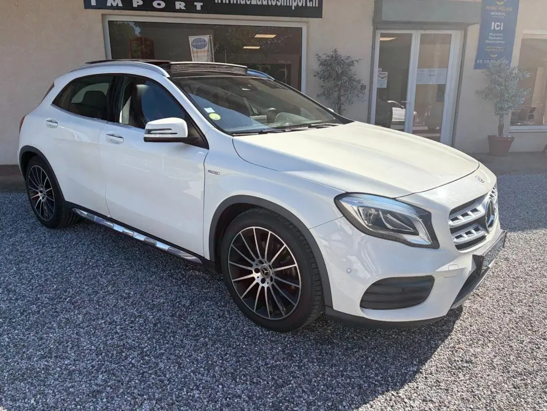 Mercedes GLA 220d blanc en 3/4 avant droit, avec jantes alliage noir et toit ouvrant panoramique visible.