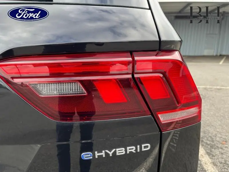Gros plan sur le feu arrière droit noir nacré du Volkswagen Tiguan 1.4 eHybrid avec logo eHybrid visible.