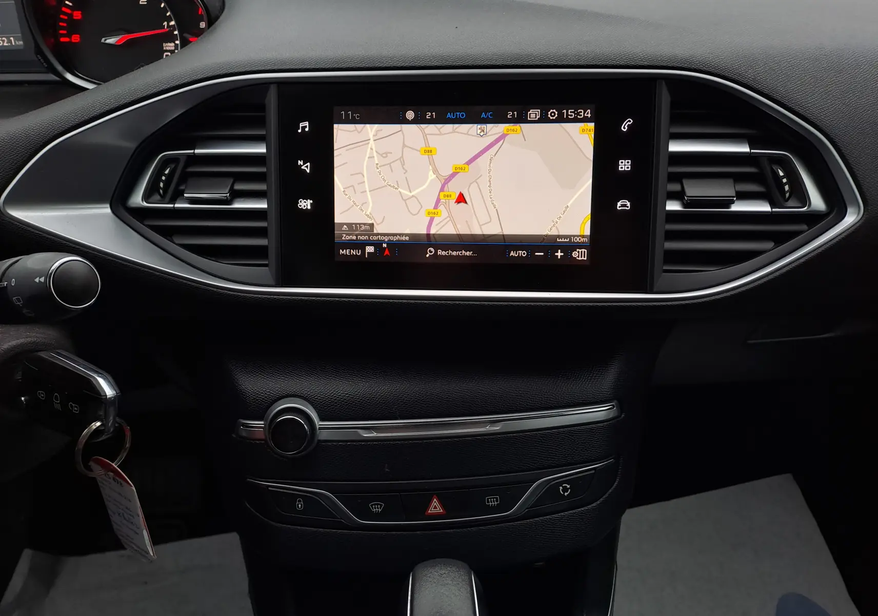 Vue rapprochée du tableau de bord noir de la Peugeot 308 2019 avec écran tactile affichant la navigation GPS.