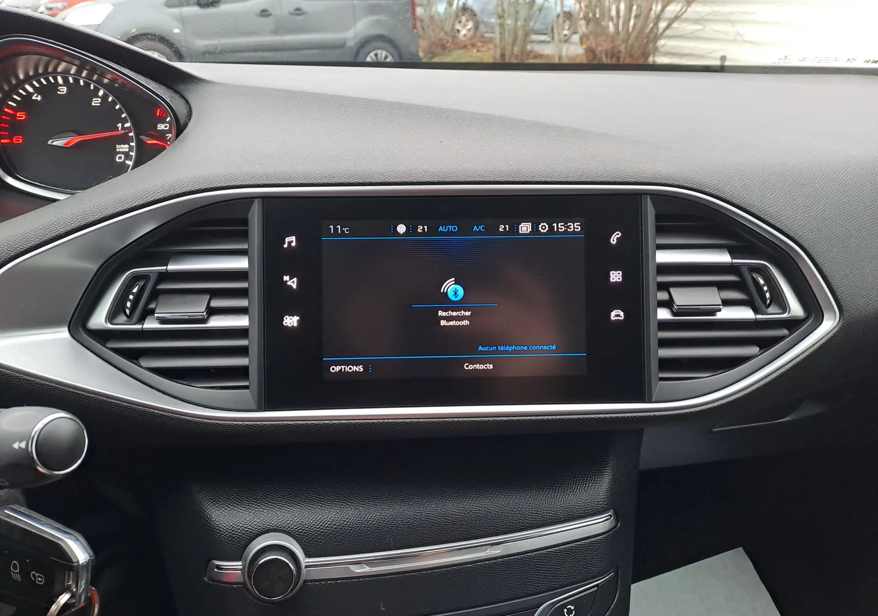 Tableau de bord noir de la Peugeot 308 2019 avec écran tactile central et commandes d'aération visibles en gros plan.