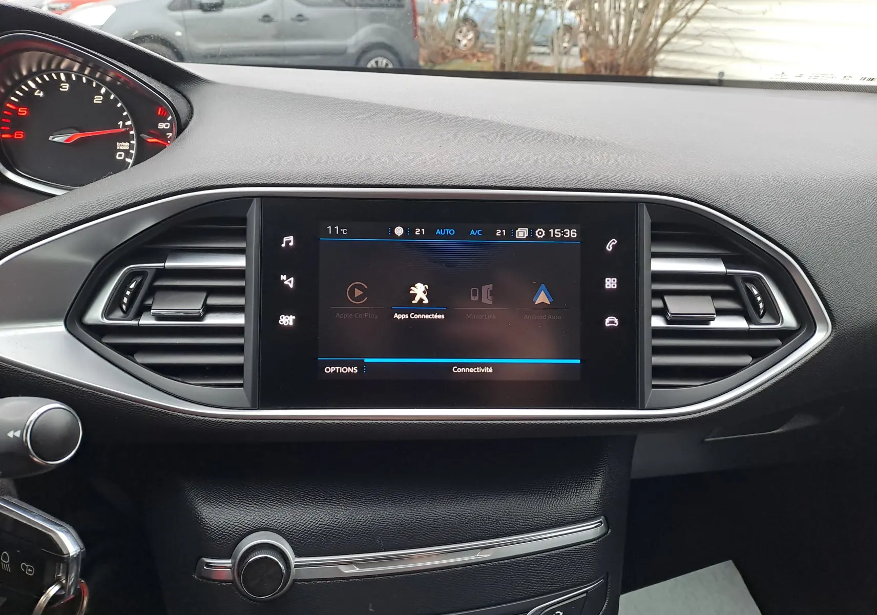 Tableau de bord noir de Peugeot 308 2019 avec écran tactile central affichant les applications connectées.