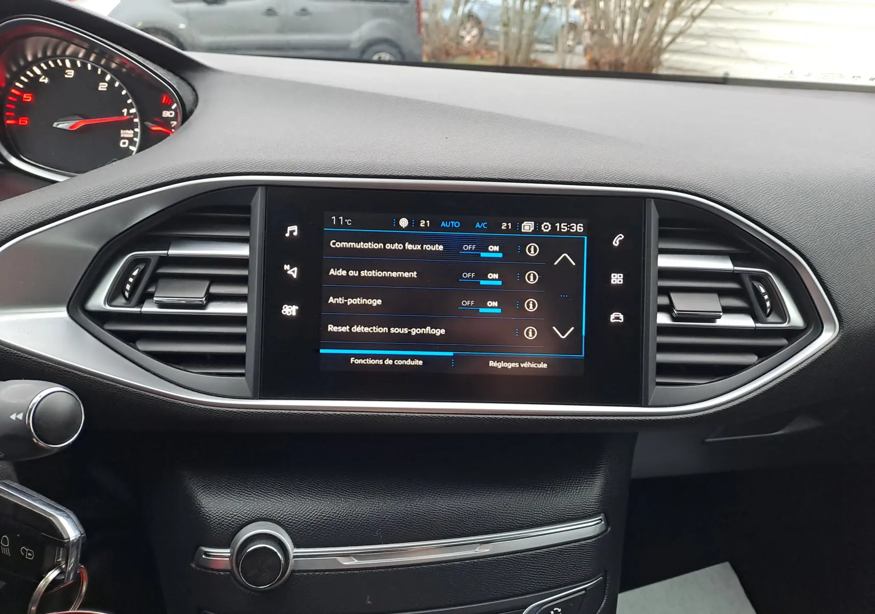 Tableau de bord noir de Peugeot 308 2019 avec écran tactile affichant les réglages d'aide à la conduite.