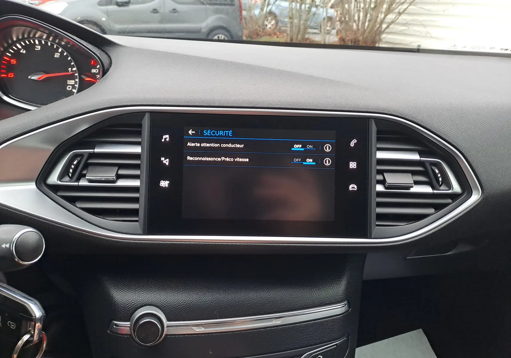 Vue rapprochée du tableau de bord noir de la Peugeot 308 2019 avec écran tactile affichant les options de sécurité.