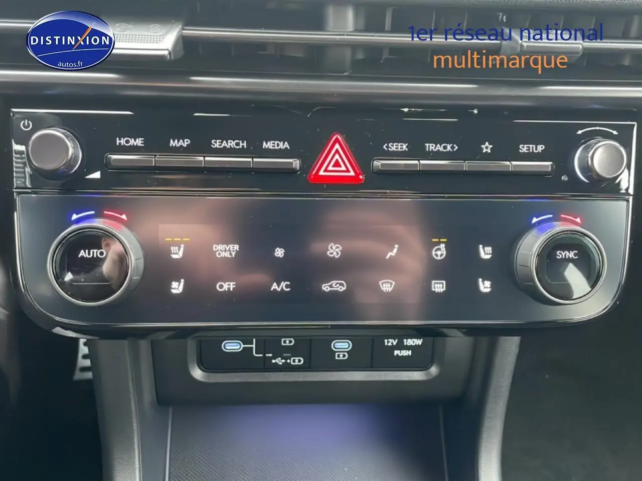 Gros plan sur la console centrale noire du Hyundai Tucson 2025 avec commandes climatisation et écran tactile.