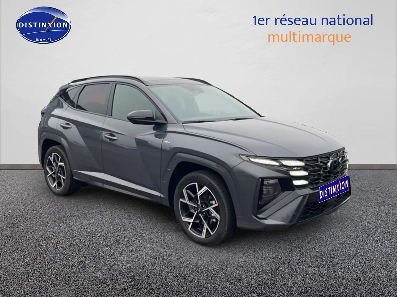 Vue 3/4 avant du Hyundai Tucson gris écotronique avec calandre N Line et jantes alliage 19 pouces design sportif.