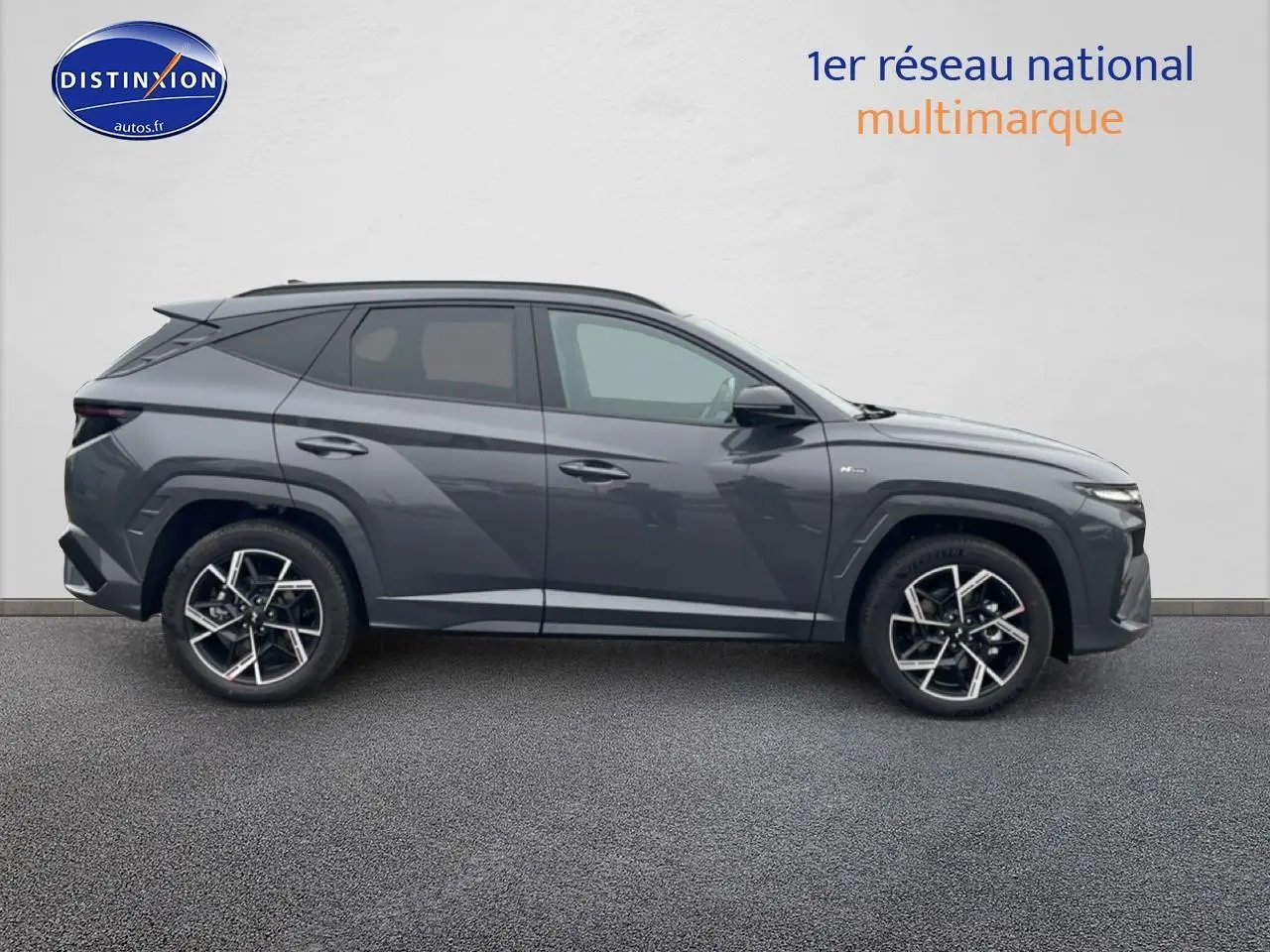 Vue de profil côté gauche du Hyundai Tucson 2025 gris ecotronique avec jantes alliage 19 pouces design N-Line.