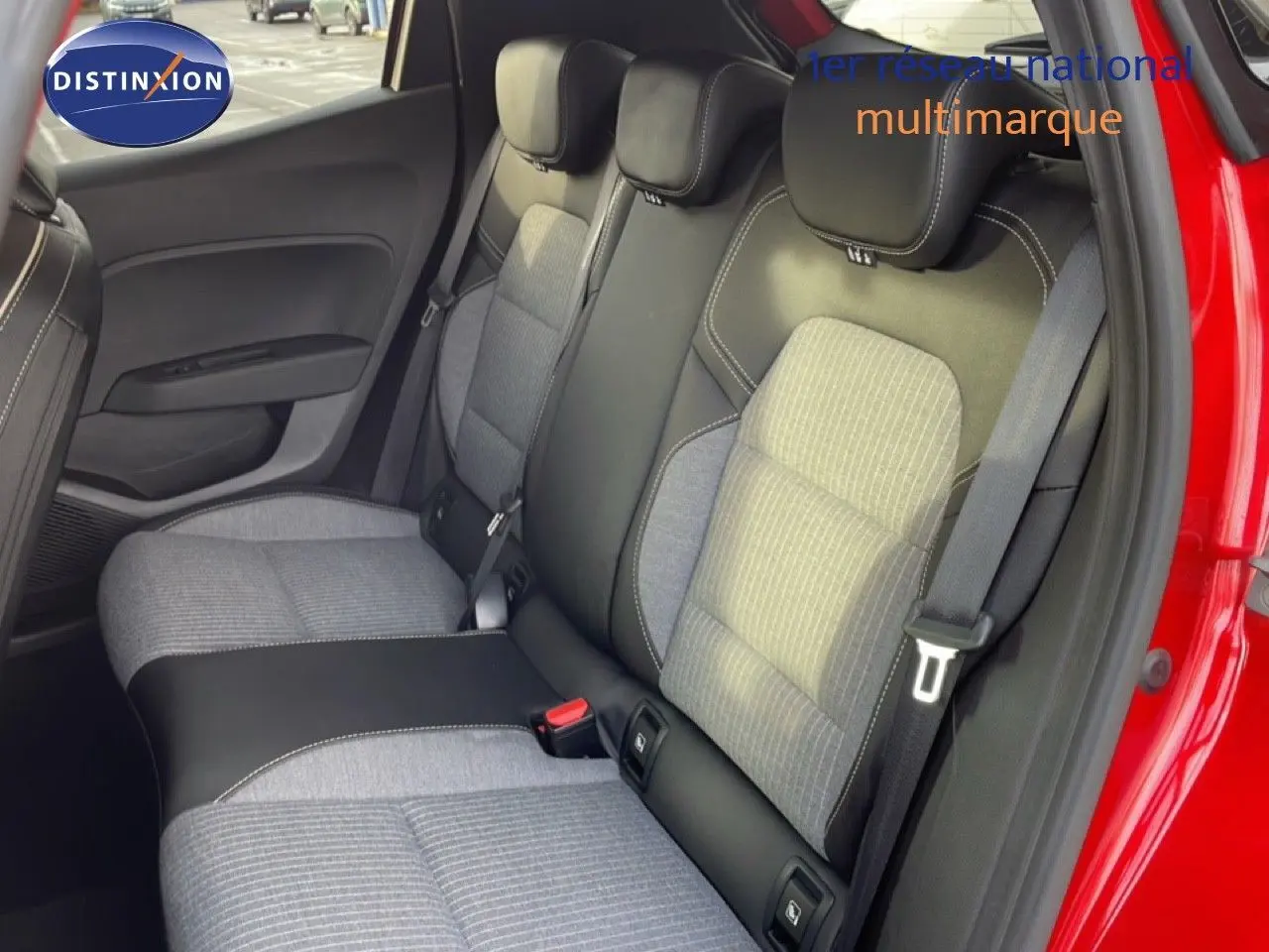 Vue intérieure côté droit des sièges arrière en tissu gris et cuir noir d'une Renault Clio rouge Désir Métal 2025.