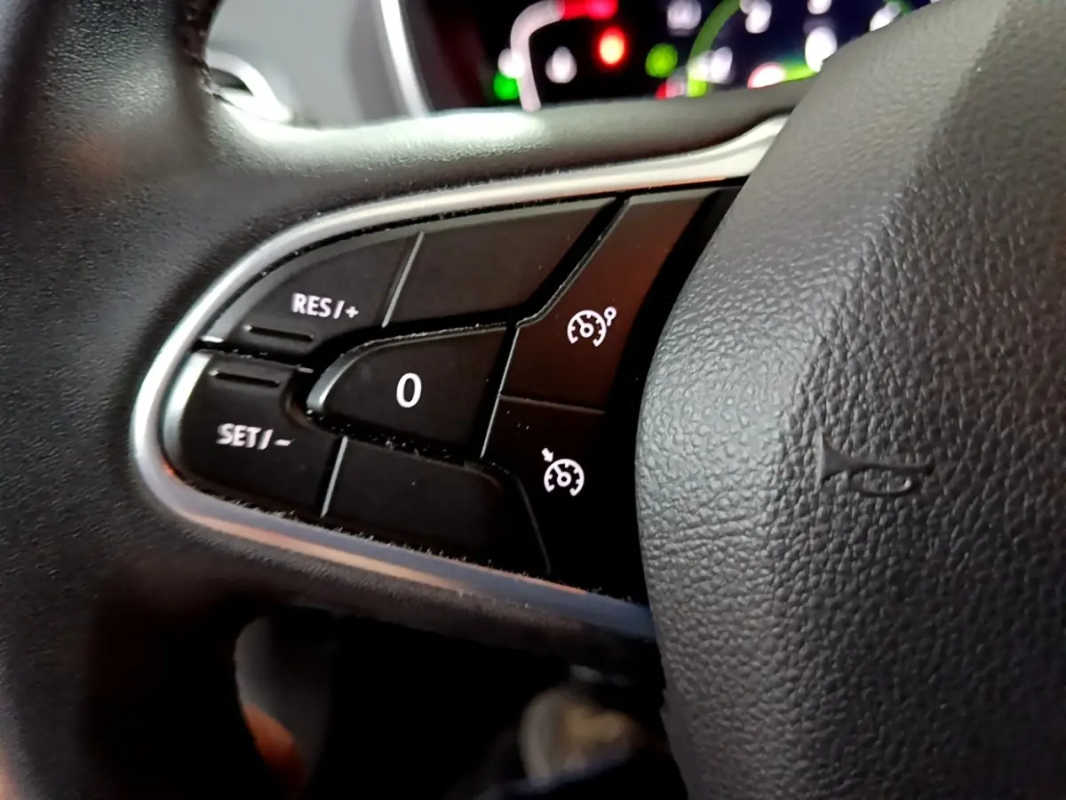 Gros plan sur les commandes du régulateur de vitesse du volant noir de la Renault Mégane Business Blue dCi 115 EDC 2021.