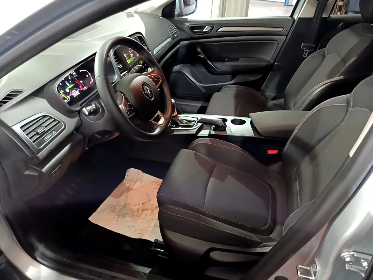Vue intérieure côté conducteur de la Renault Mégane Business Blue dCi 115 EDC 2021, sièges noirs et tableau de bord digital.