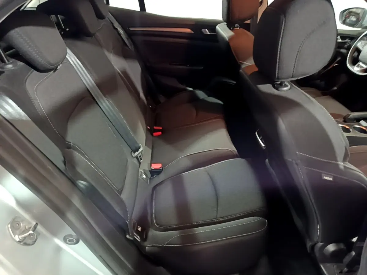 Vue intérieure côté gauche montrant la banquette arrière noire et les sièges avant d'une Renault Mégane gris clair 2021.