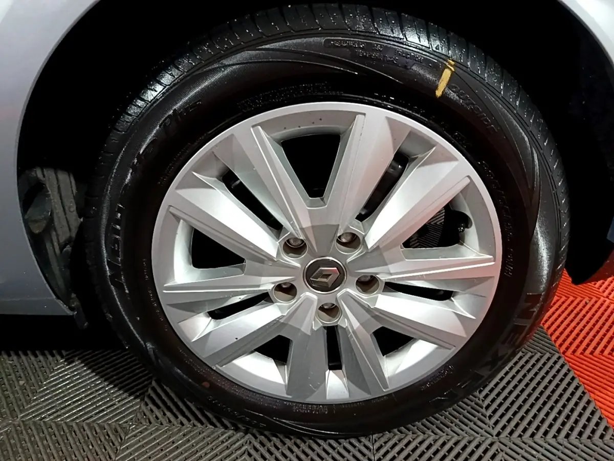 Gros plan sur la roue avant droite de la Renault Mégane Business Blue dCi 115 EDC gris clair avec jante alliage argentée.