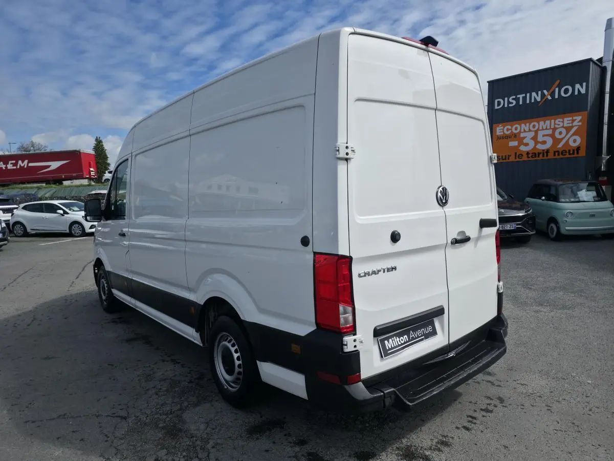 Vue 3/4 arrière droite d'un Volkswagen Crafter fourgon blanc avec portes arrière battantes et jantes acier.
