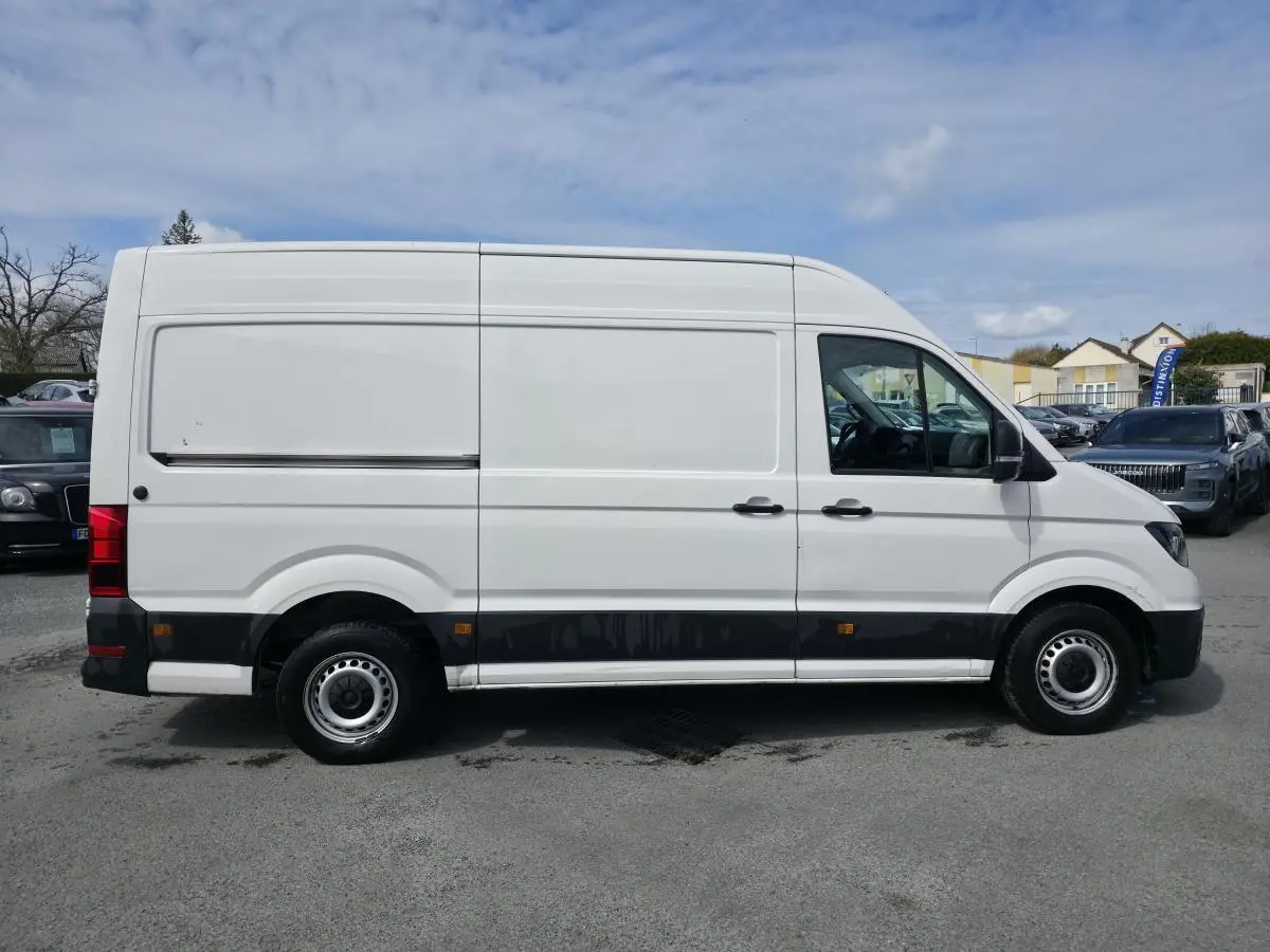 Volkswagen Crafter Fourgon blanc en profil droit, avec portes latérales coulissantes et jantes acier argentées.