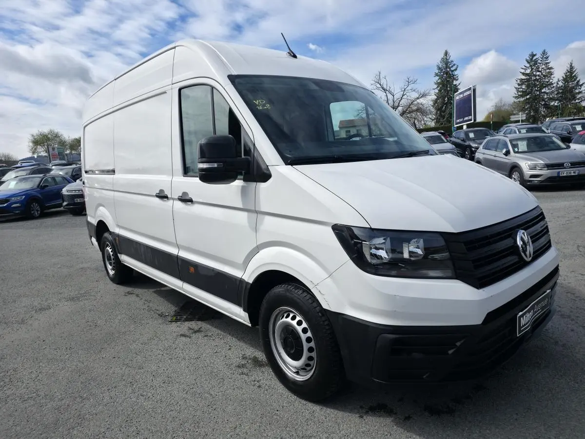 Volkswagen Crafter fourgon blanc vu en 3/4 avant droit avec protections noires et jantes acier argentées.