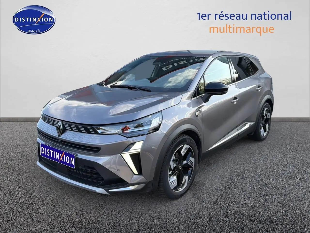 Renault Symbioz gris métallisé en 3/4 avant droit, avec jantes noires et phares LED distinctifs.