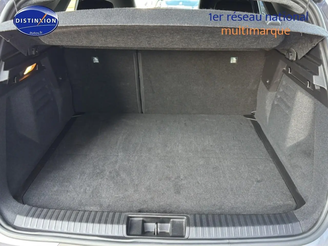 Coffre ouvert gris clair de la Renault Symbioz 1.6 e-tech full hybrid 2025, vue plongeante sur l’espace de chargement vide.