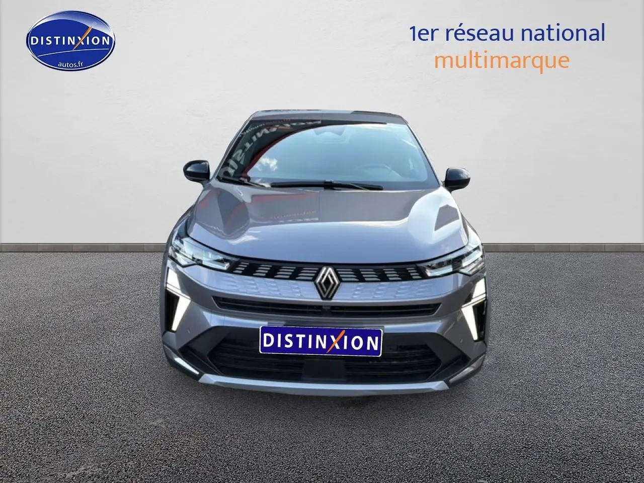 Vue avant d'une Renault Symbioz grise 2025 avec calandre moderne et feux LED verticaux allumés.