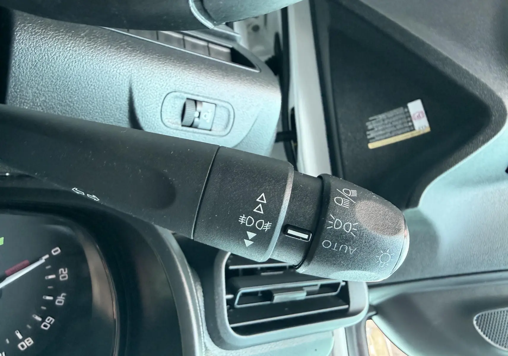 Gros plan sur la commande des feux du Citroën Berlingo 2019, intérieur noir avec détails de la planche de bord.