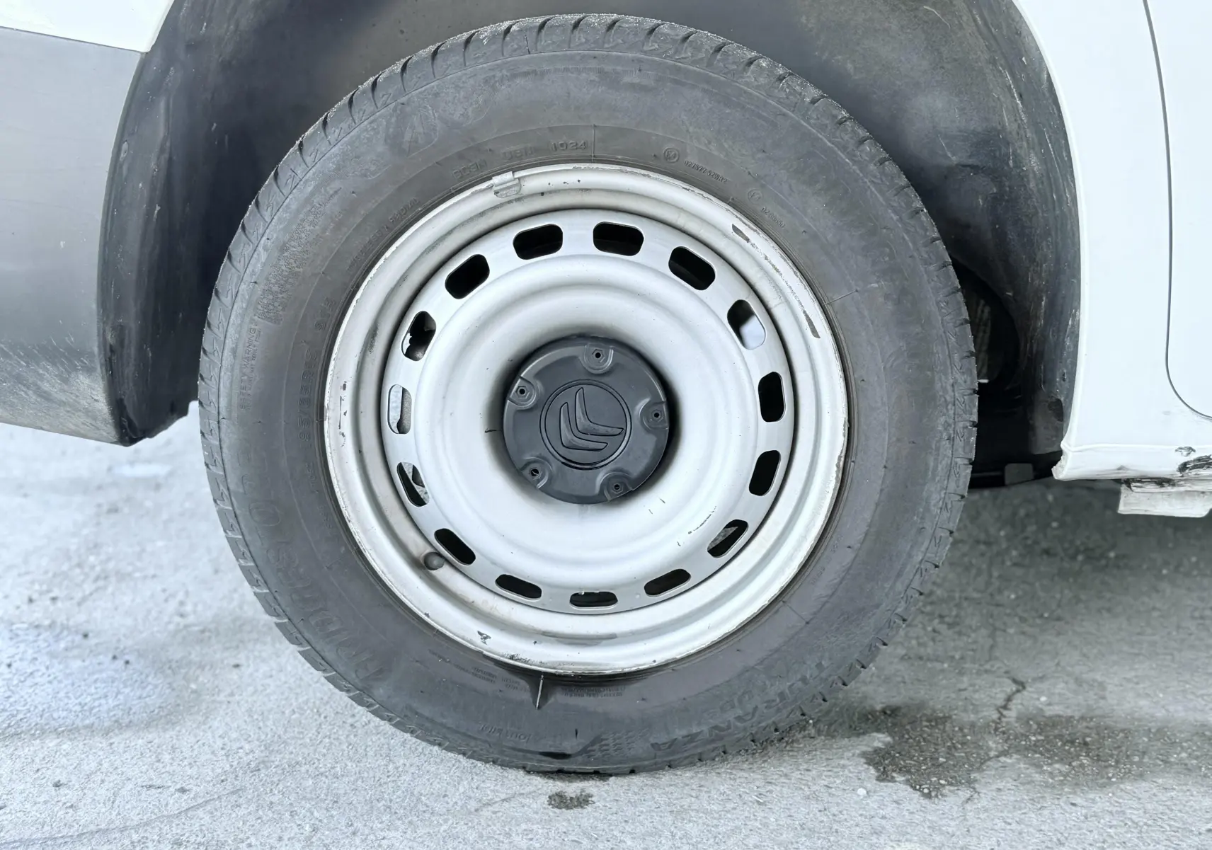 Gros plan sur la roue avant droite blanche d’un Citroën Berlingo 2019 avec jante acier et logo Citroën central.