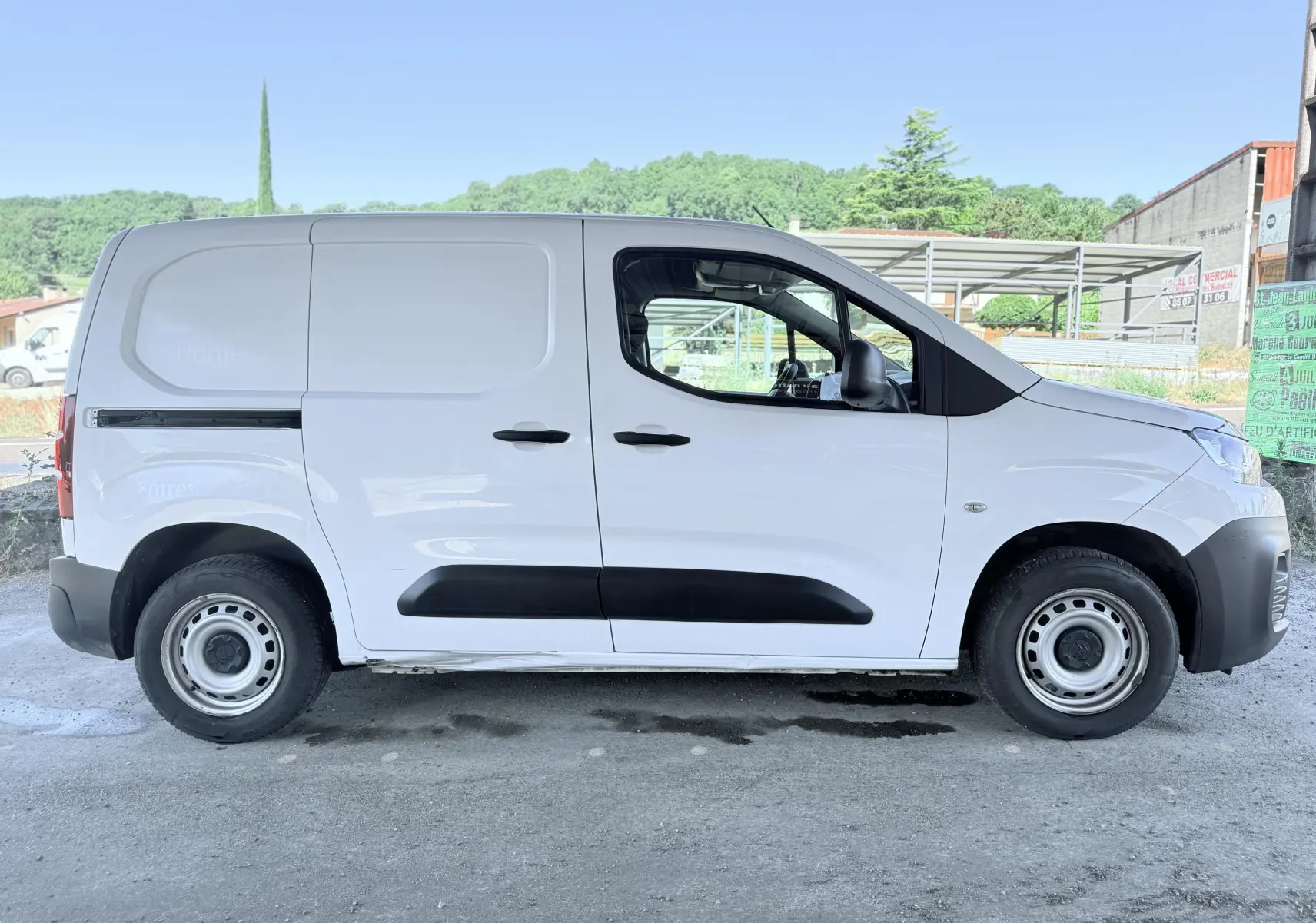 Vue de profil côté gauche d’un utilitaire Citroën Berlingo blanc avec protections noires et jantes acier.