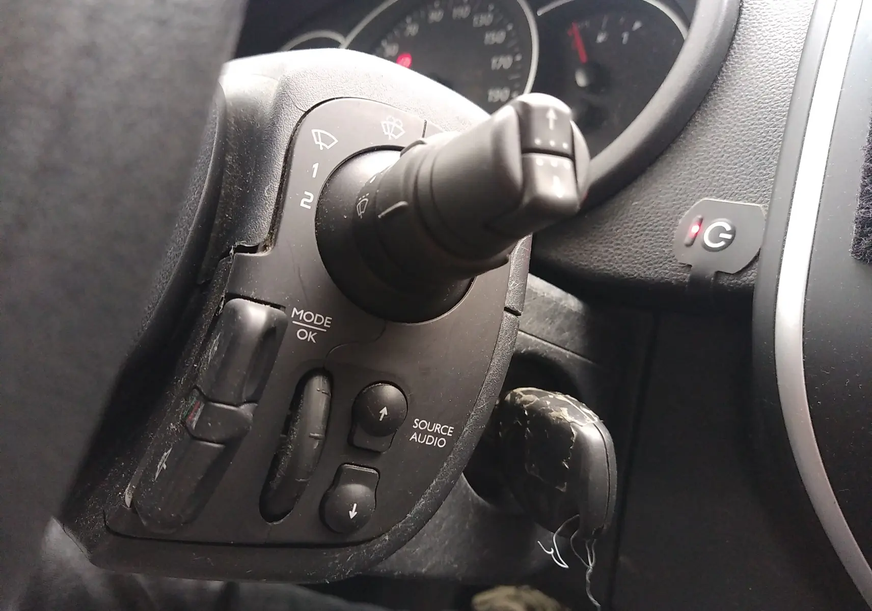 Gros plan sur la commande de régulateur et les boutons audio au volant d'un Renault Kangoo blanc de 2019.