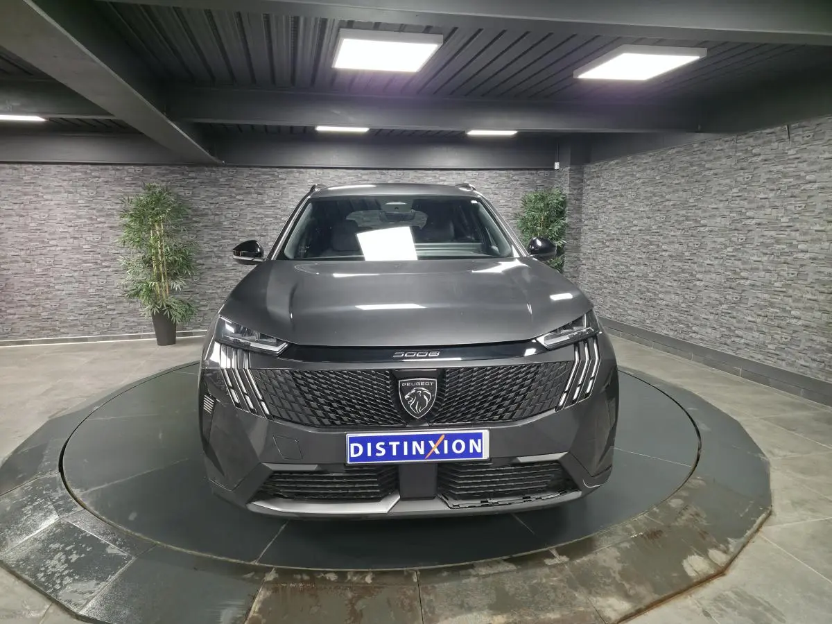 Vue avant centrée du Peugeot 5008 gris métallisé avec calandre noire et feux LED à griffes distinctifs.
