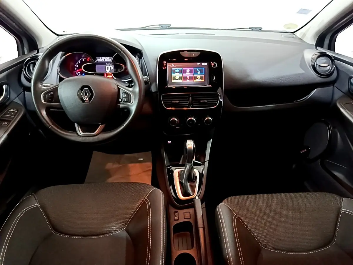 Vue intérieure avant de la Renault Clio Business 2018, tableau de bord noir avec écran tactile central et volant cuir multifonctions.