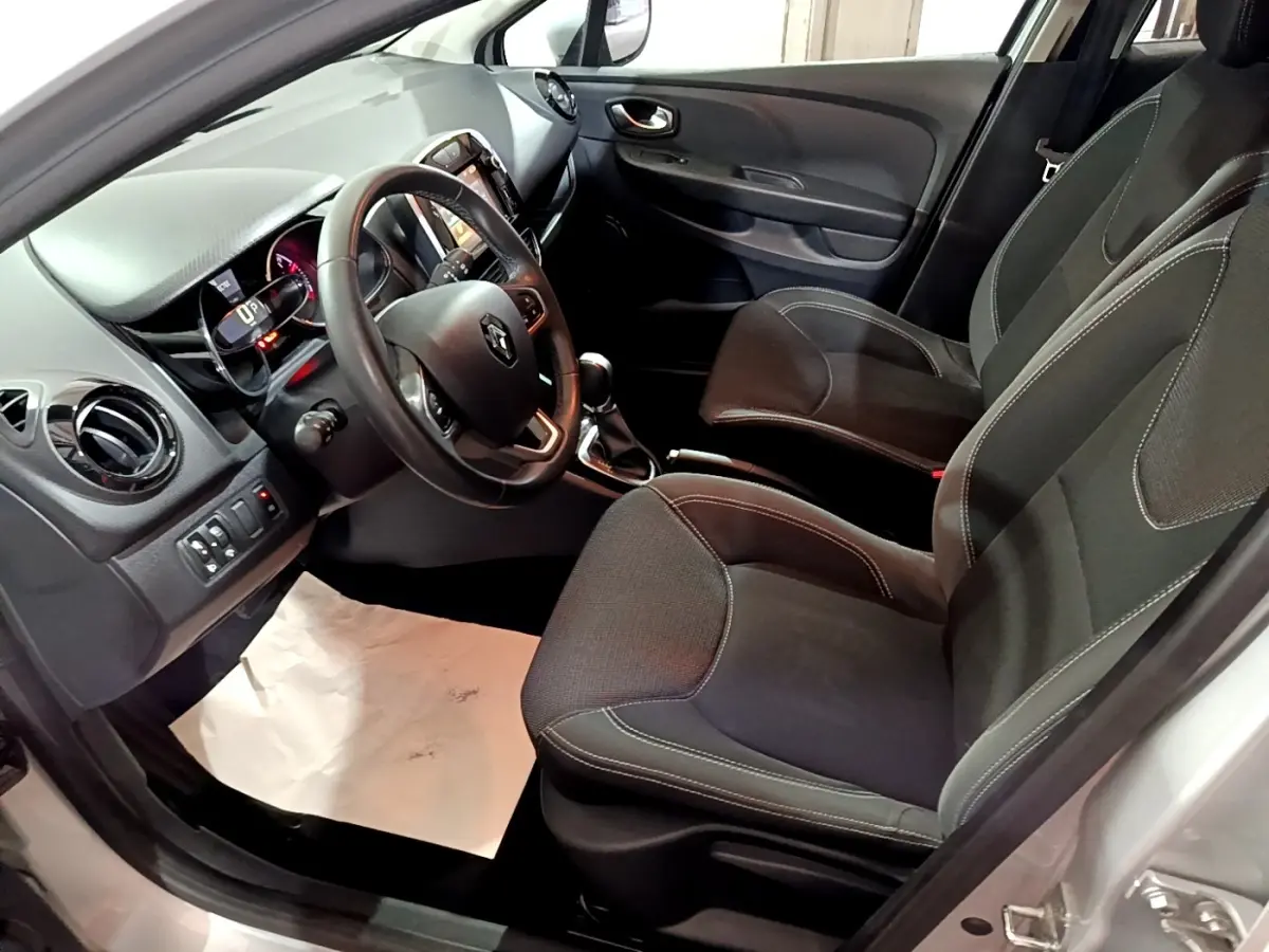 Vue intérieure côté conducteur de la Renault Clio Business 2018, volant cuir multifonctions et sièges tissu noirs.