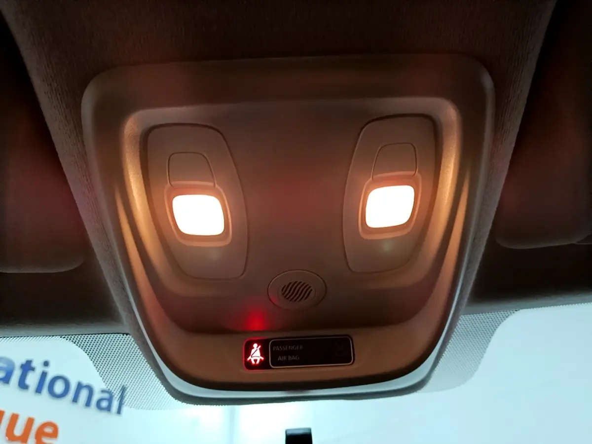 Plafonnier intérieur allumé avec témoin de ceinture passager sur Renault Clio Business gris clair, vue vers le toit avant.