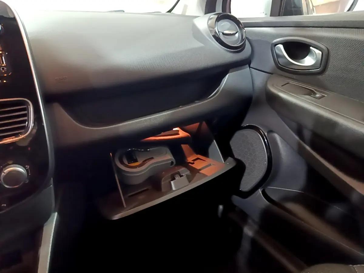 Vue intérieure côté passager de la Renault Clio Business 2018, boîte auto, avec boîte à gants ouverte et tableau de bord noir.