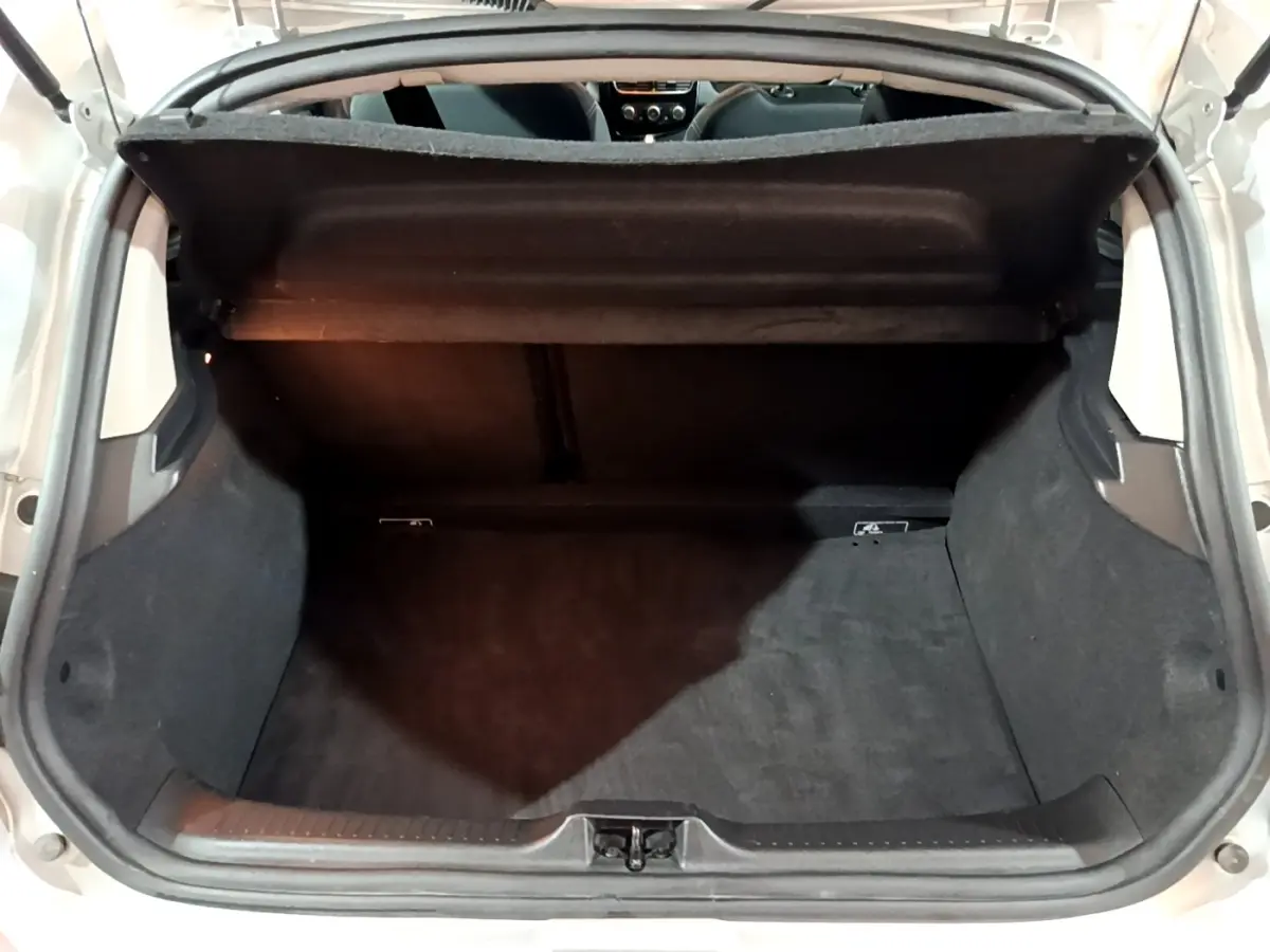 Coffre ouvert vu de l'arrière d'une Renault Clio Business gris clair, montrant l'espace de chargement vide et la tablette arrière.