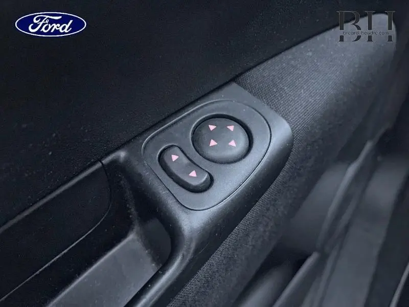 Gros plan sur les commandes de réglage des rétroviseurs côté conducteur, plastique noir mat.