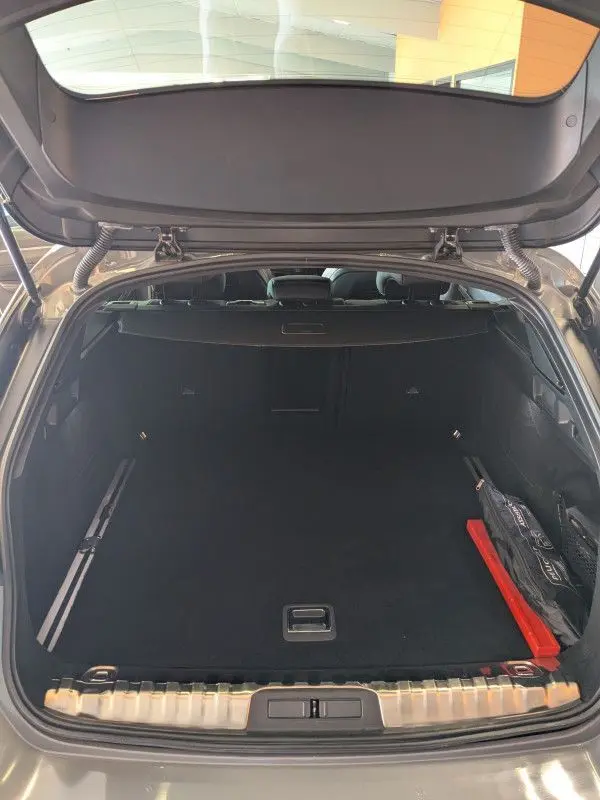 Coffre ouvert du Peugeot 508 SW gris Selenium, vue arrière montrant un espace de chargement spacieux et bien fini.