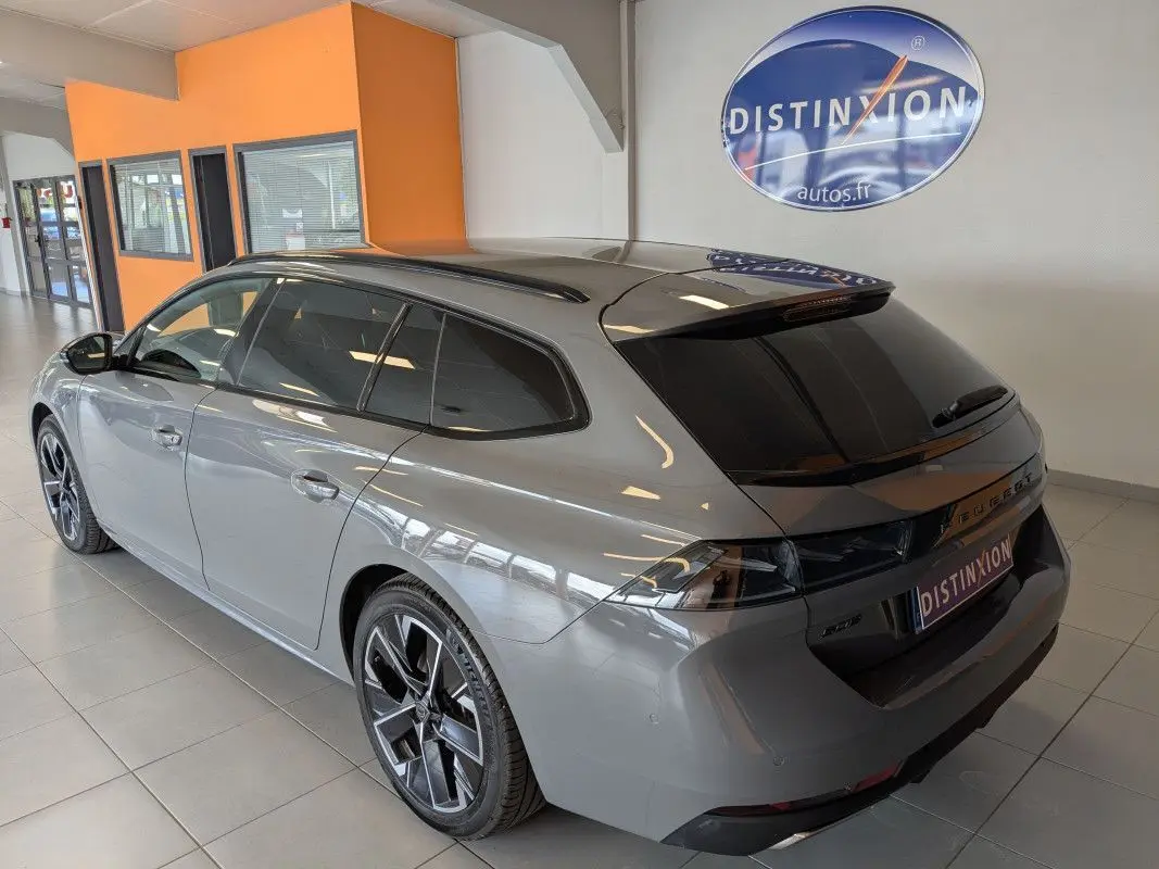 Peugeot 508 SW gris Selenium vue 3/4 arrière droit en intérieur, vitres surteintées et jantes alu 18 pouces.