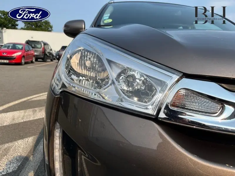 Gros plan sur le phare avant gauche du Citroën C4 Aircross brun Mangaro, soulignant la calandre chromée et les détails lumineux.