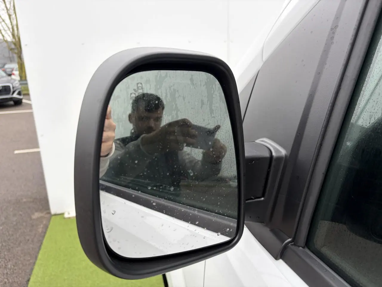 Rétroviseur extérieur côté gauche du Peugeot Expert Fourgon blanc Icy avec traces de pluie sur la vitre.